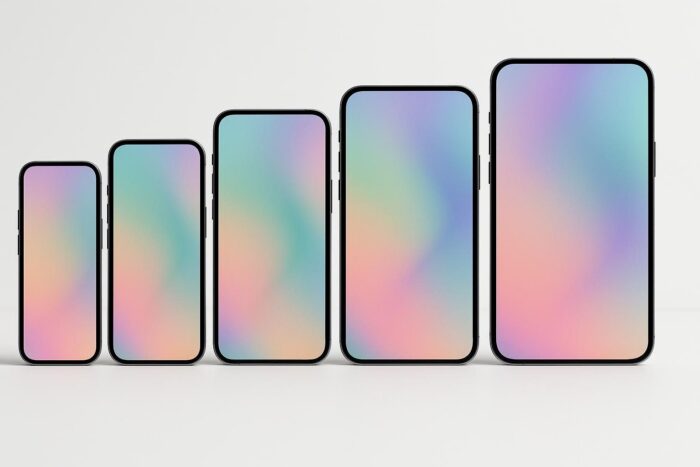 Current iPhone models of increasing sizes standing in a row in a white studio